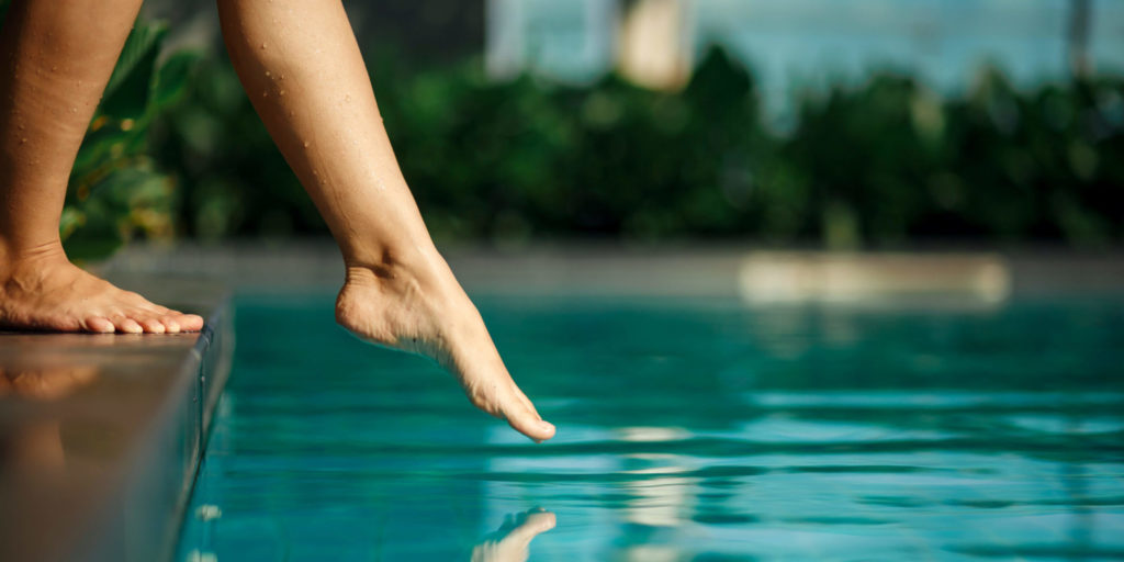 Woman dipping her toes in the pool